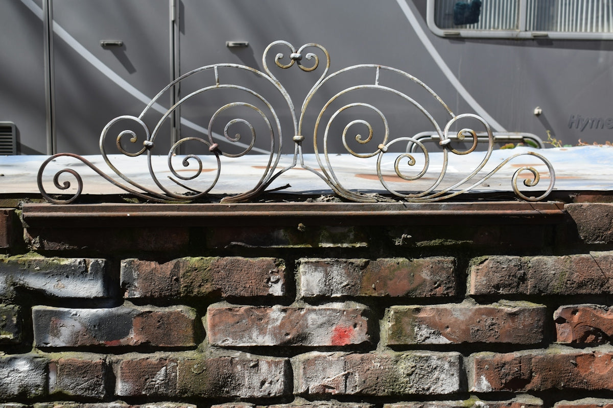 Ornamental metalwork sits atop a brick wall