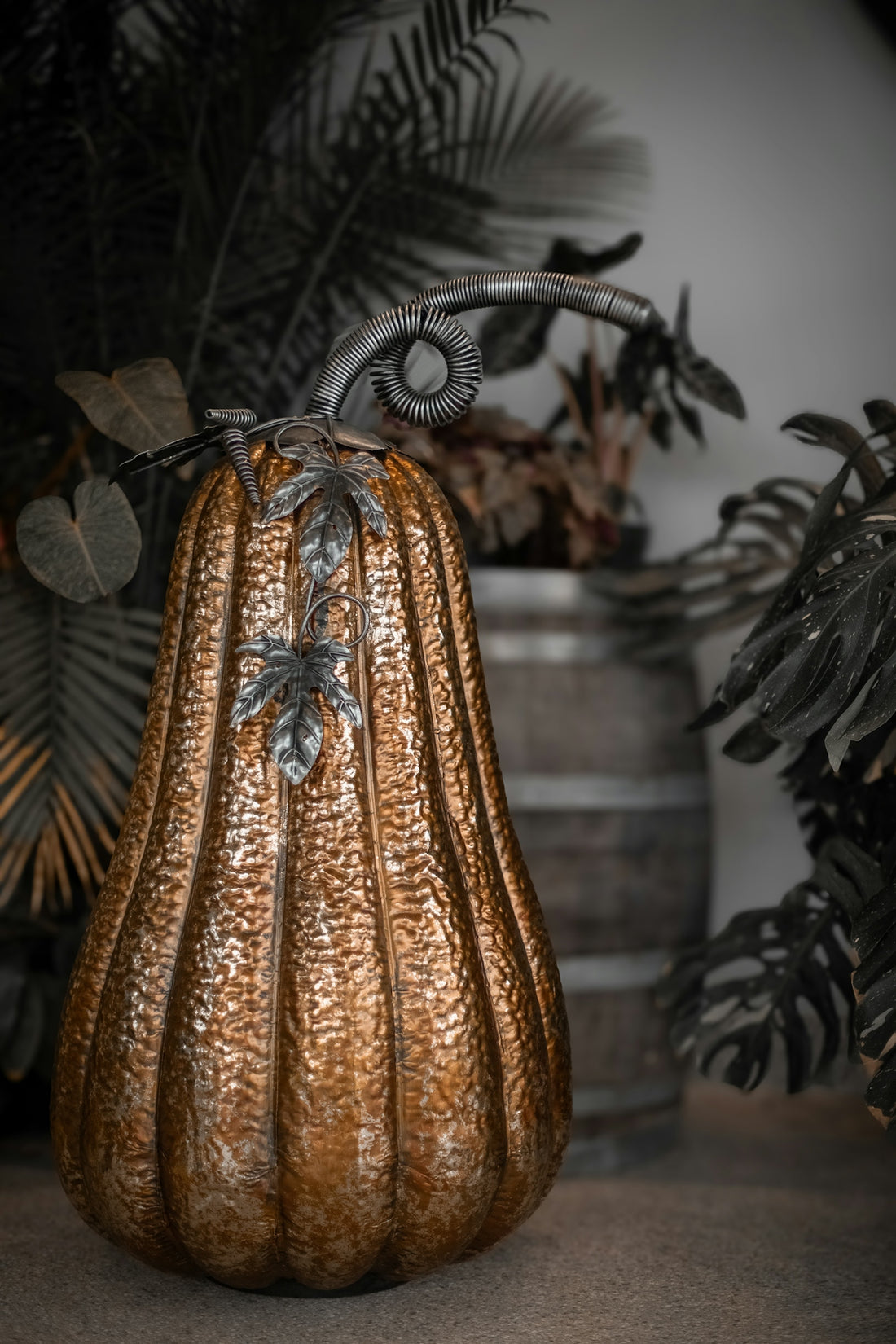 A decorative metallic pumpkin with ornate stem and leaves