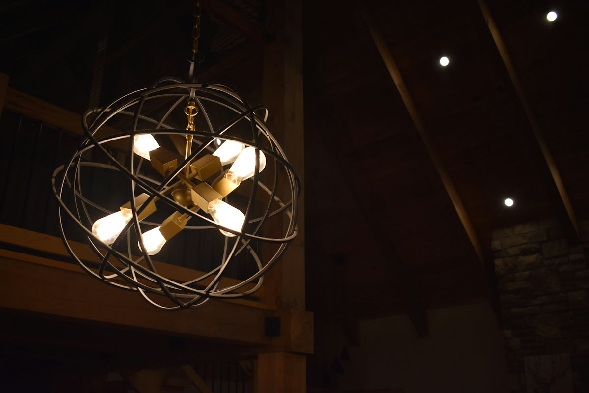 A spherical metal chandelier with exposed bulbs