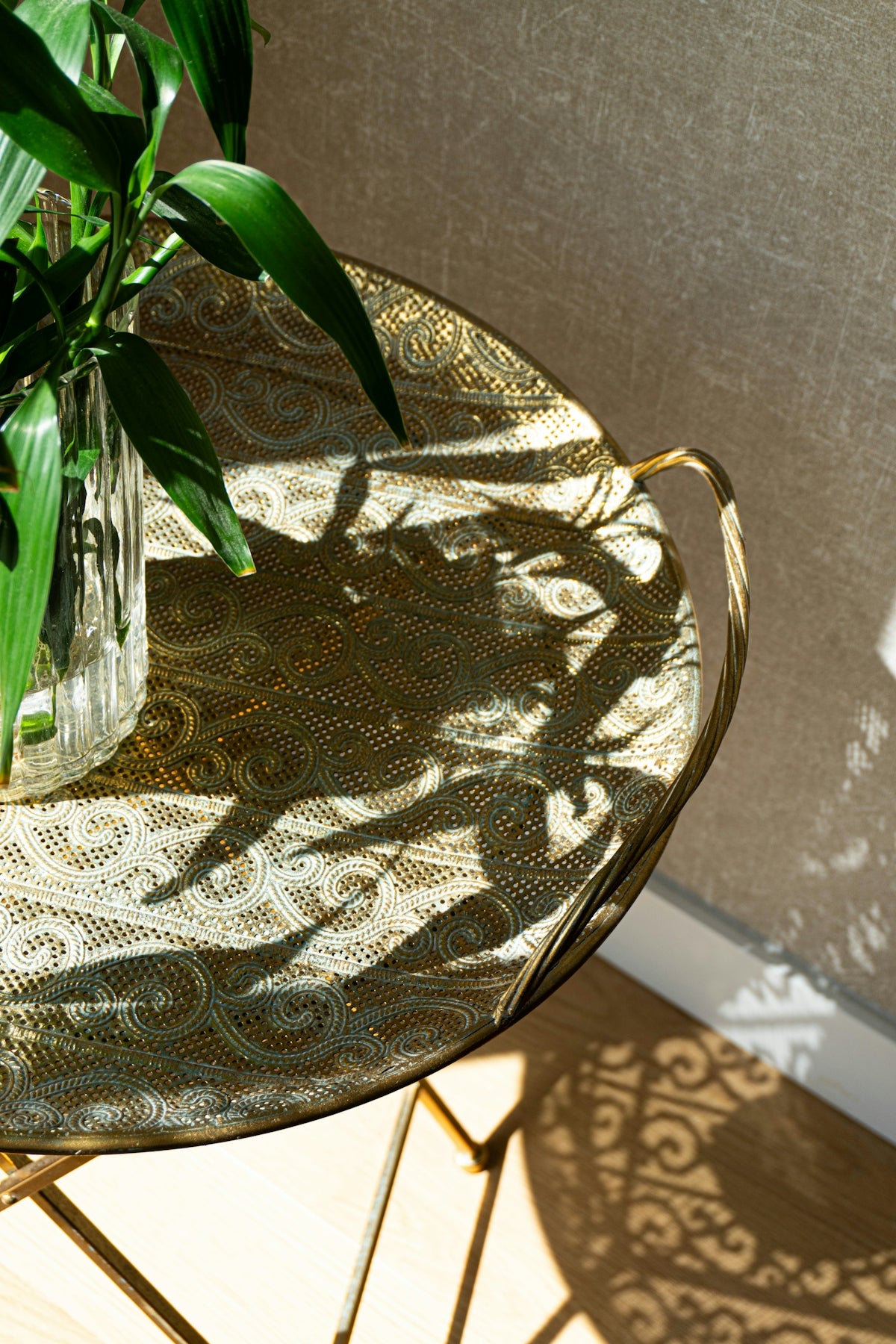 A decorative table with patterned shadows and plant