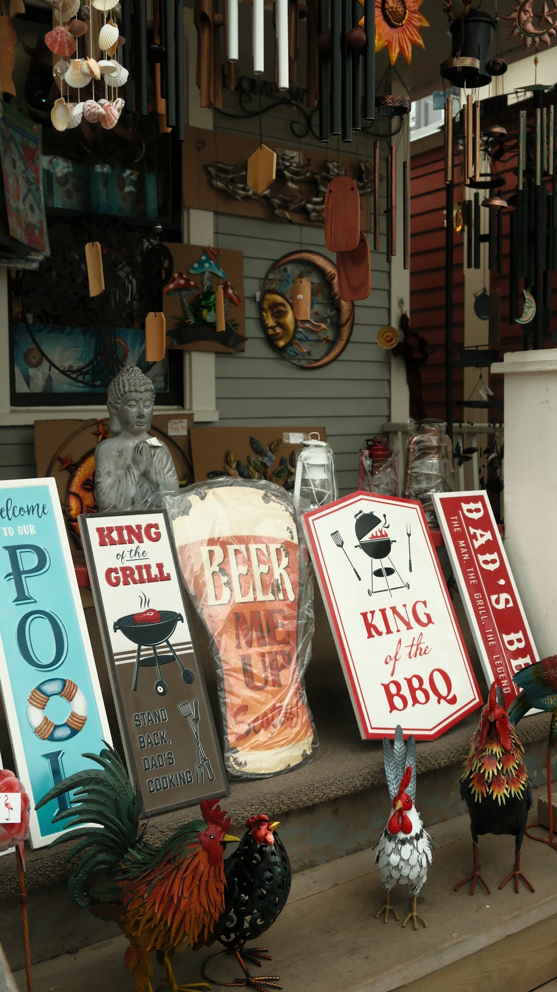 Decorative signs and rooster statues displayed on porch steps