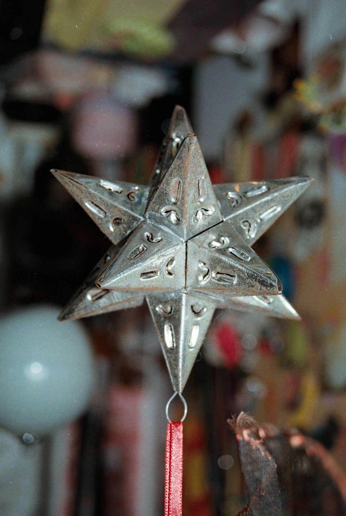 A metallic star ornament with a red ribbon