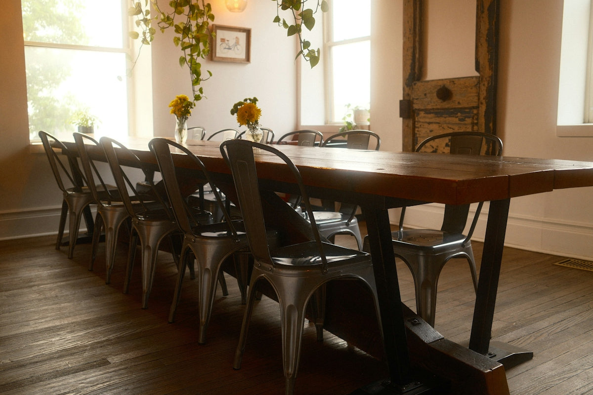 Long wooden dining table with metal chairs in bright room