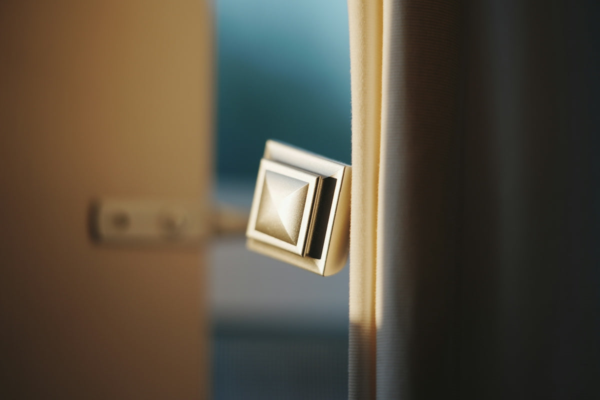 A square, metallic door handle on a partially open door