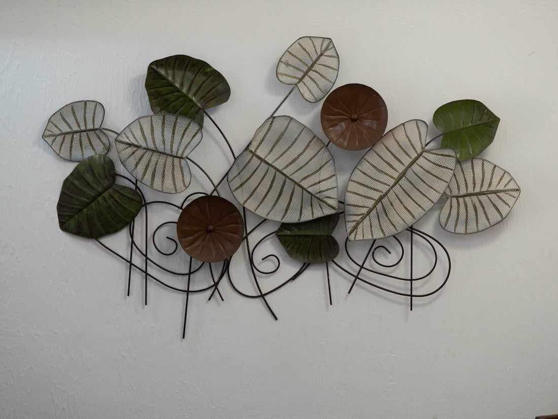 Metal wall art featuring green and white leaves